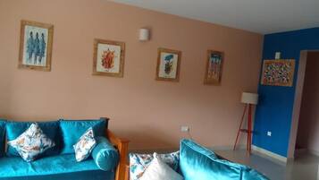 Basic Apartment, Pool View | Living area | Flat-screen TV