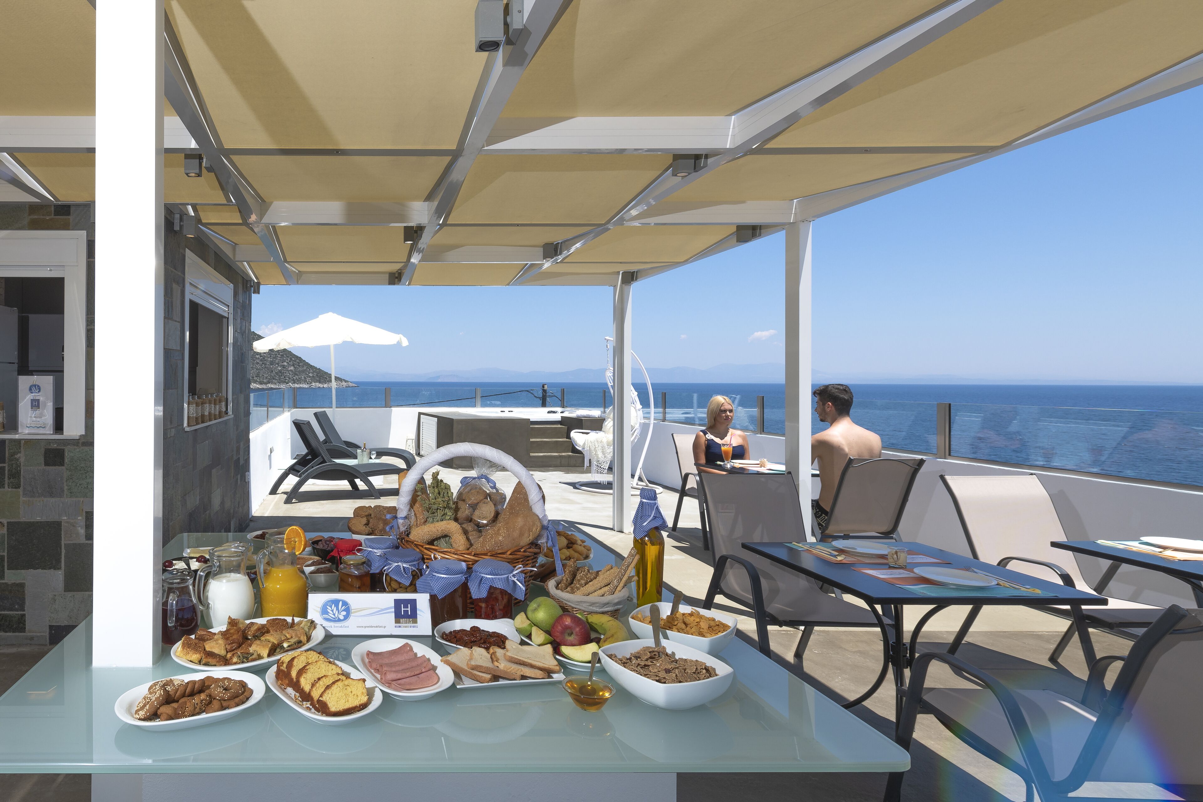Un bufé de desayuno con diferentes alimentos sobre una mesa, con vistas al mar.