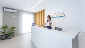 A hotel reception desk with a modern design, a wooden panel wall, and a logo for 'Hotel & Spa'.
