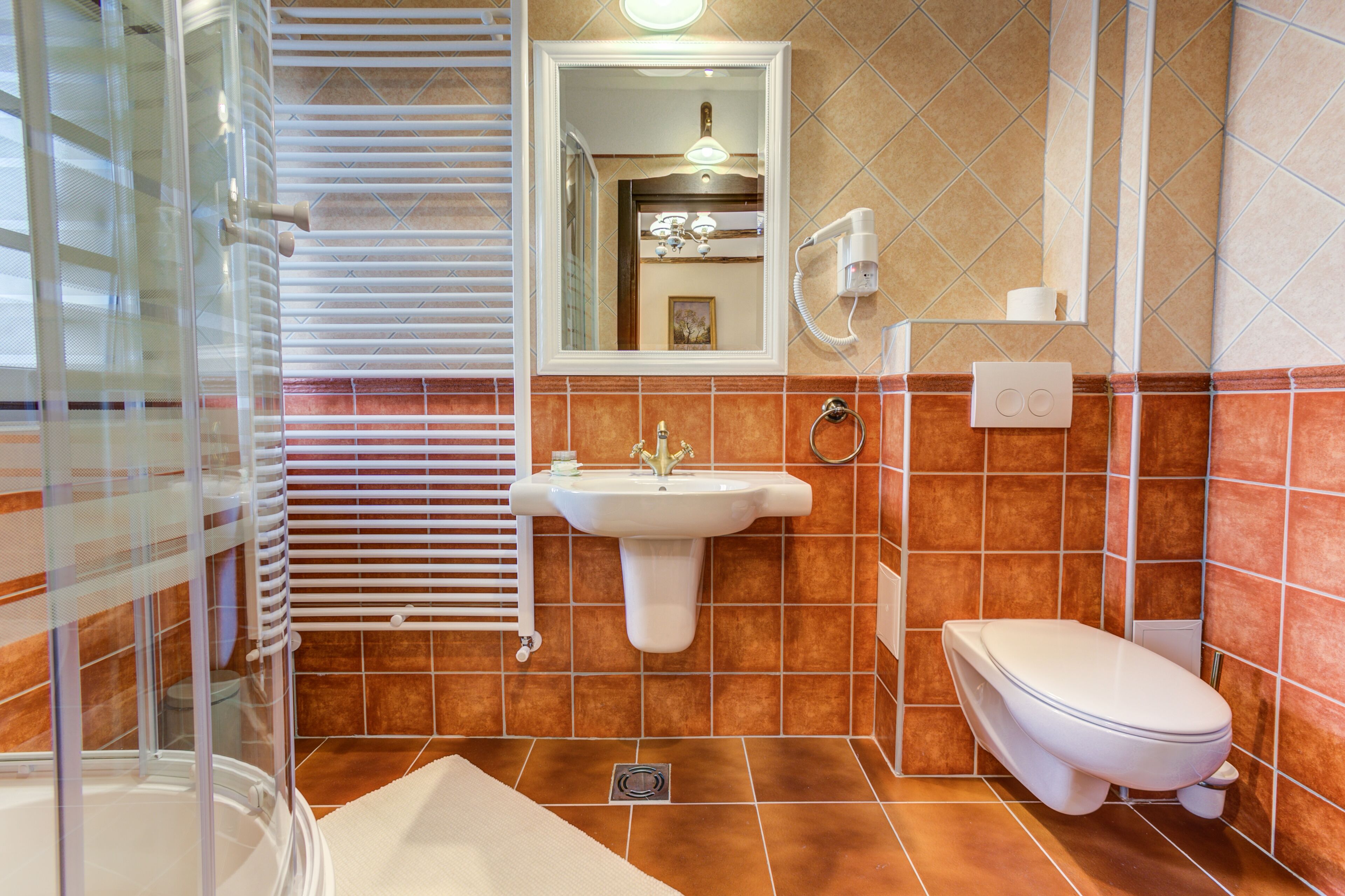 A bathroom with a glass shower enclosure, a sink, a toilet, and a mirror.