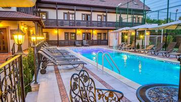 Una piscina techada, una piscina al aire libre de temporada, sombrillas