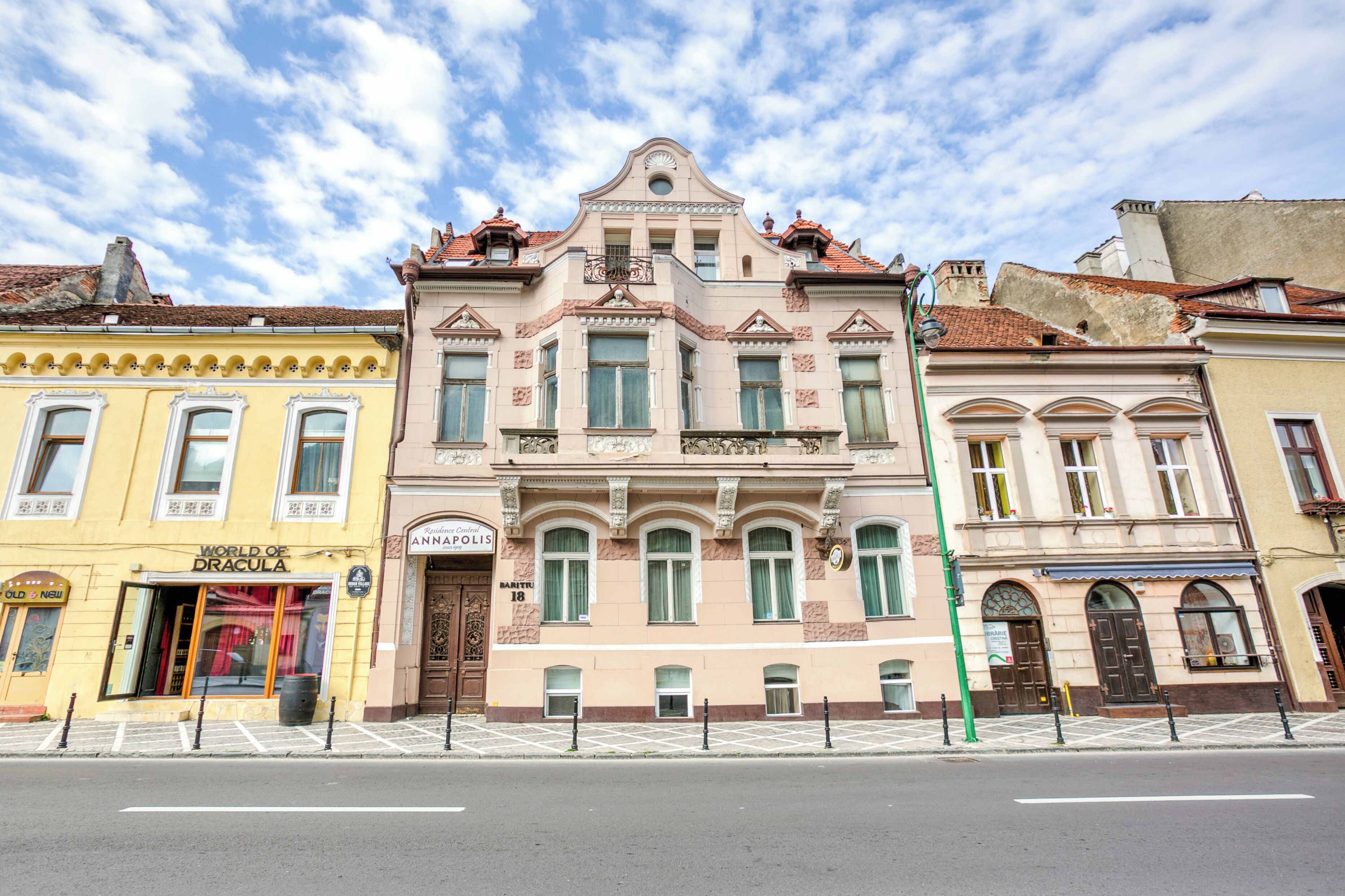 Un edificio histórico con arquitectura ornamentada, una entrada destacada y vista a la calle.