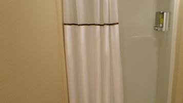 A bathroom with a shower curtain, a toilet, and a bathtub.