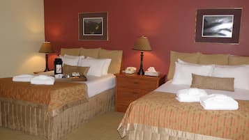 Two double beds with matching headboards, bedside tables with lamps, and a small bedside table with a telephone.