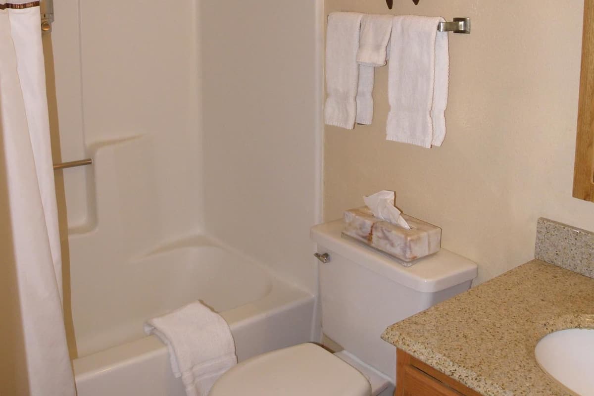 A bathroom with a bathtub, toilet, and vanity.