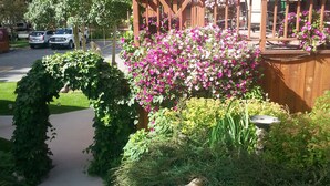 A pathway leading to a wooden pergola with a view of a mountain. - The River's Edge Motel Lodge & Resort (Ouray)