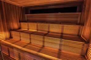 A sauna with wooden benches and slatted walls. - Hotel Roman By Dumbrava Business Resort (Roman)