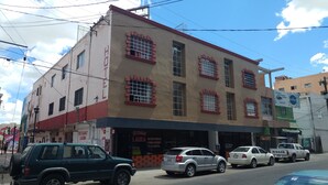 Un edificio de varios pisos con un restaurante llamado 'LAURA' en la planta baja.