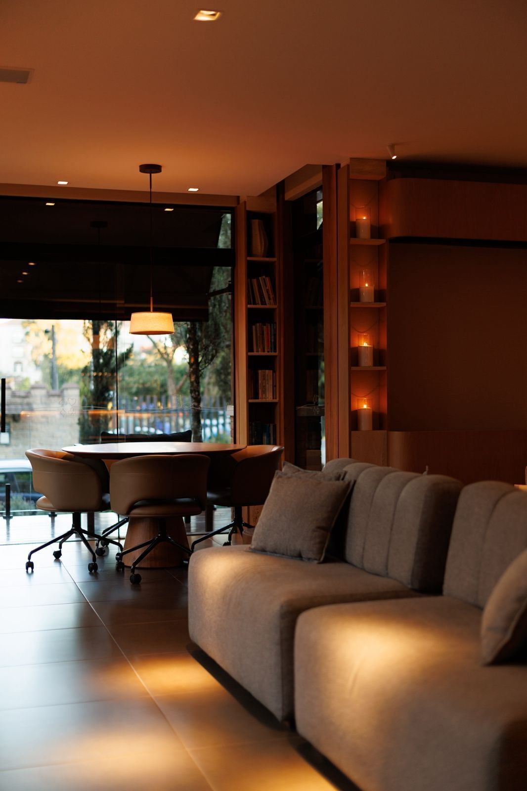 A modern living room with a sofa, a desk, and a bookshelf.