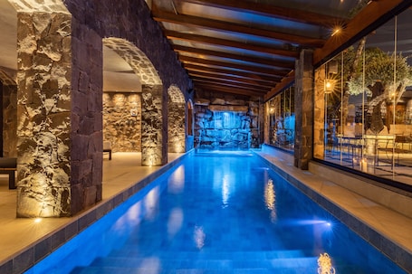 Una piscina techada, sillones reclinables de piscina