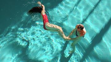 A person swimming in a pool with clear water.