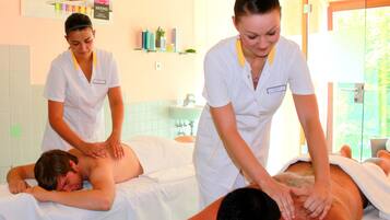A massage therapy room with two clients receiving treatments.