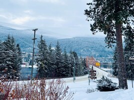 Paisaje nevado con una carretera que lleva a un cartel de bienvenida a visitantes a la ciudad de Nelson.
