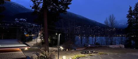 A parking area with a mountain in the background, a street lamp, and a building with a sloped roof.
