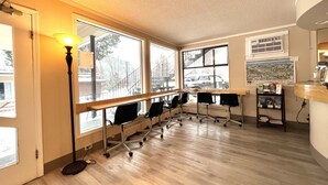 A conference room with a long table, multiple chairs, and large windows. - Villa Motel (Nelson)