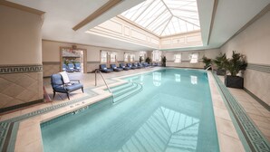 An indoor swimming pool with lounge chairs and a skylight. - The Jefferson Hotel (Richmond)