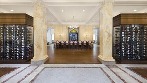 A spacious room with a long table and chairs, flanked by wine racks. - The Jefferson Hotel (Richmond)