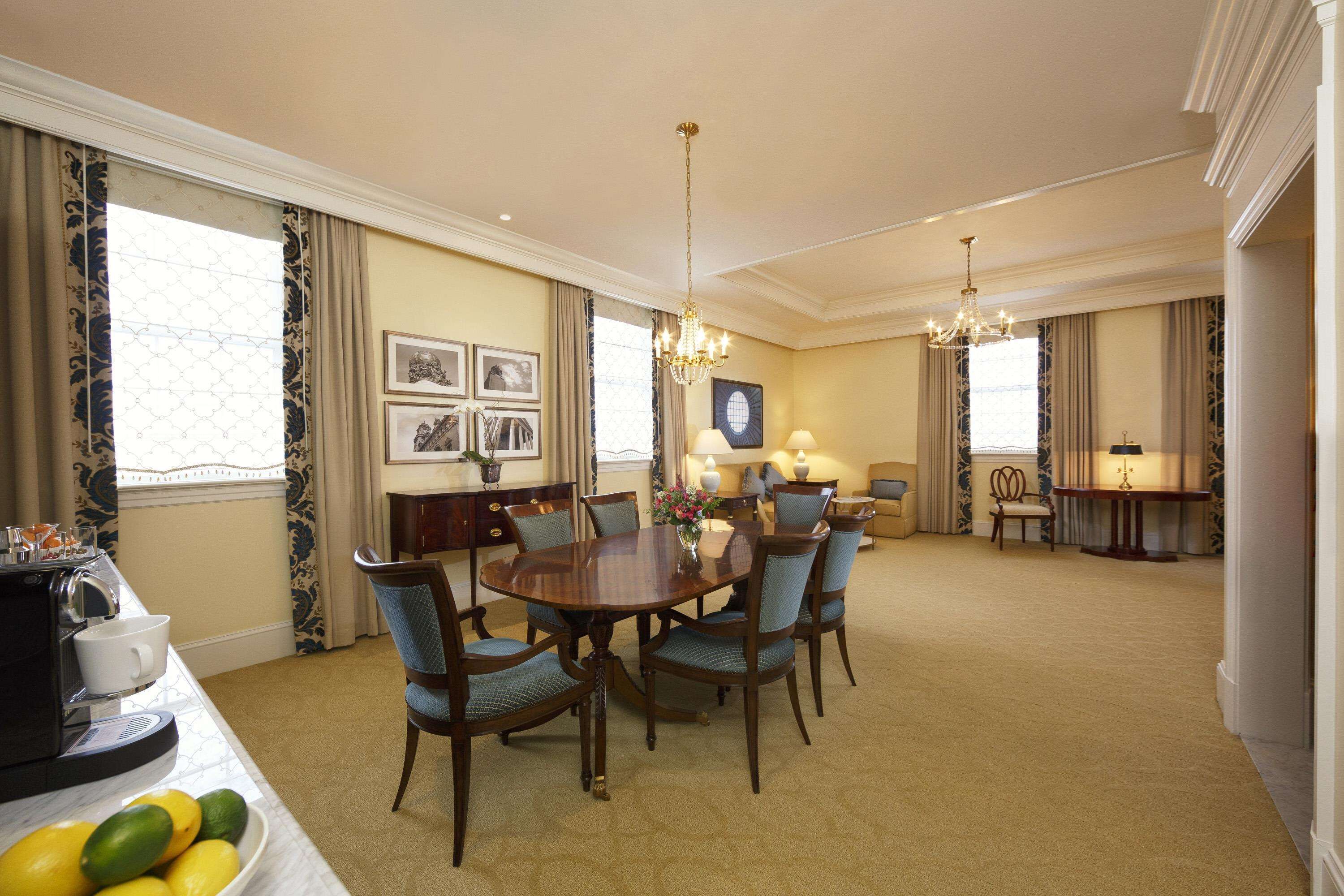 A dining area with a round table, six chairs, and a coffee station.