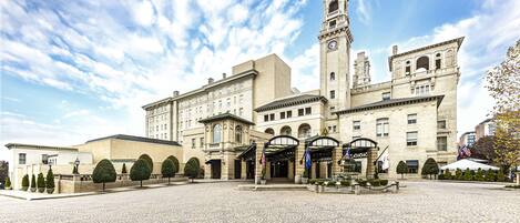 Un bâtiment historique doté d’un imposant clocher, d’une cour centrale pavée de pierres et d’une architecture symétrique.