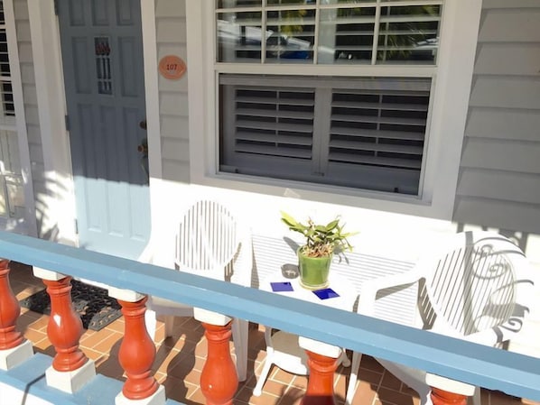 A balcony with a table, chairs, and a potted plant. - Coral Reef Guesthouse (Fort Lauderdale)