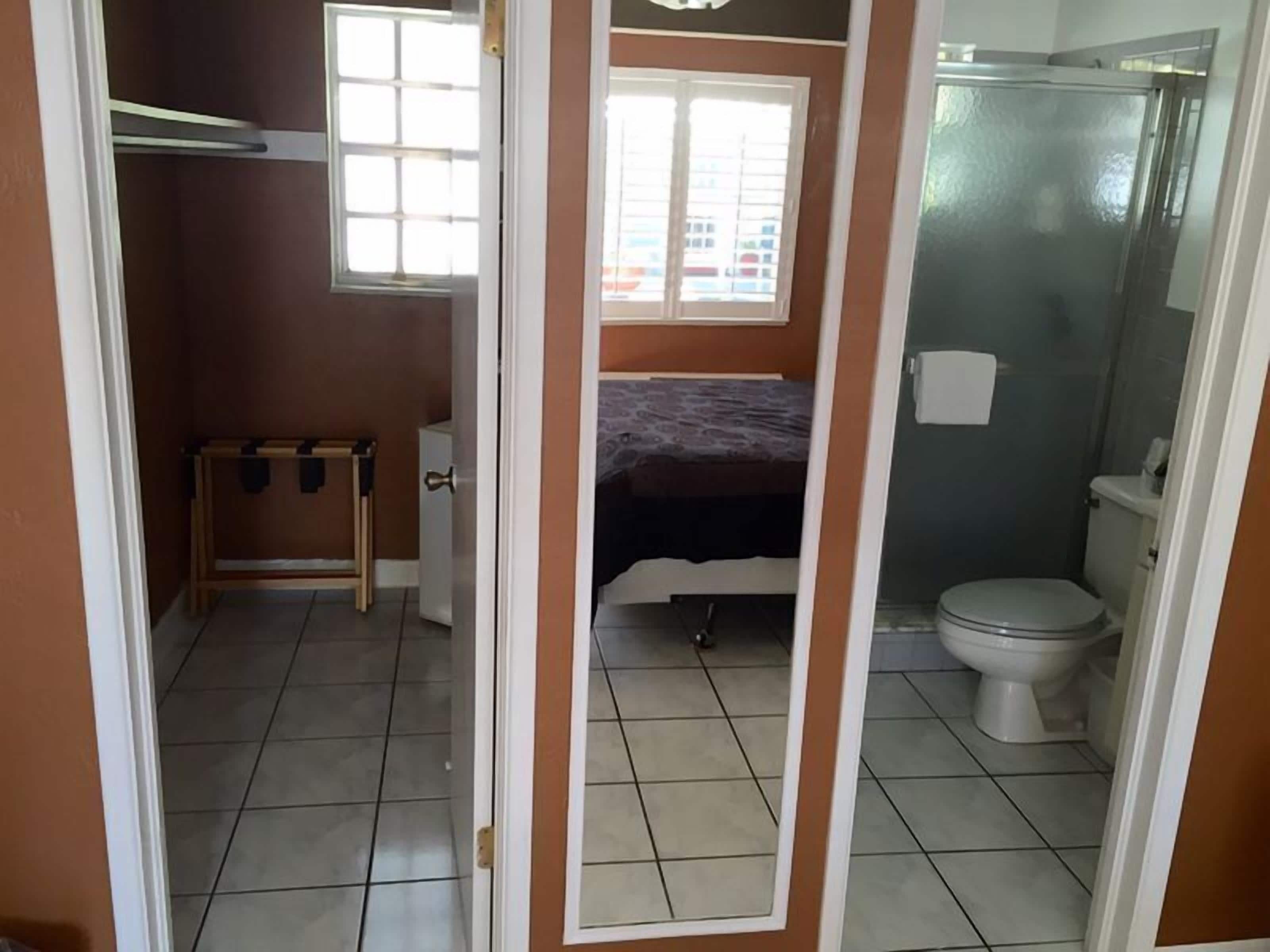 Una habitación pequeña y funcional con cama, una mesita y un inodoro.