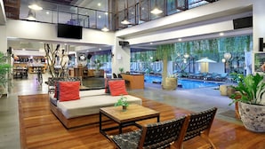 A spacious lobby with a pool area, seating arrangements, and a bar. - Hotel NEO+ Kuta, Legian by ASTON (Kuta)