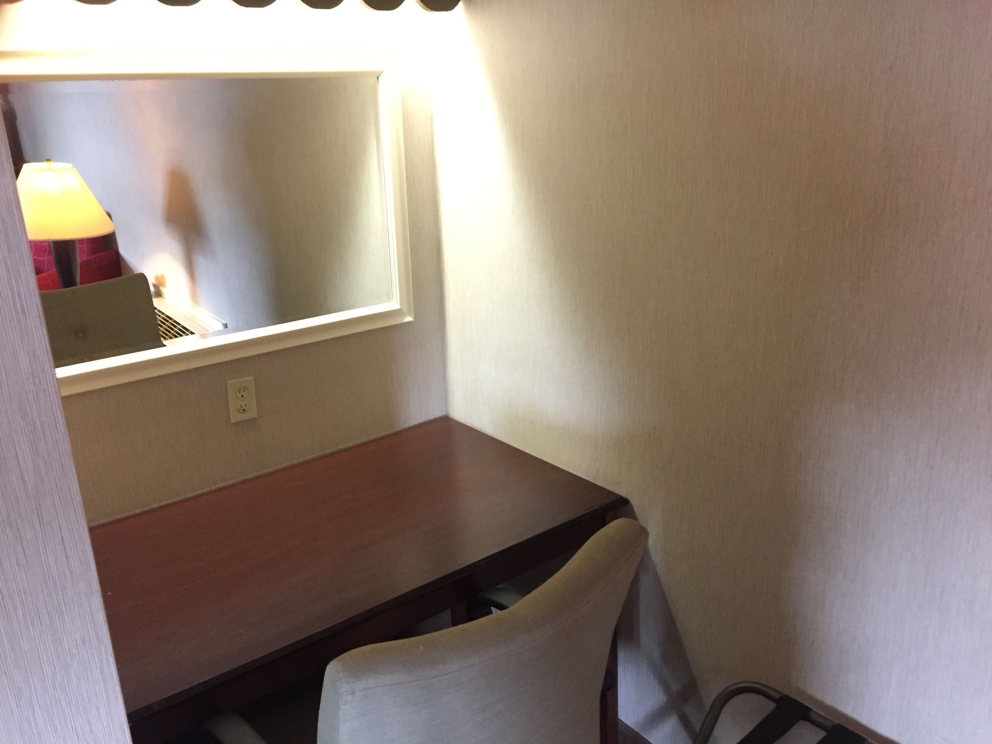 Een kleine, privé kamer met een enkel bed, nachtkastje en een raam met uitzicht.