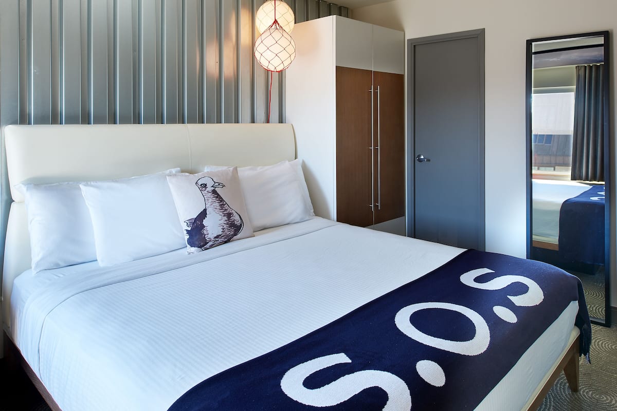 Una habitación de hotel con cama, armario, puerta y ventana.
