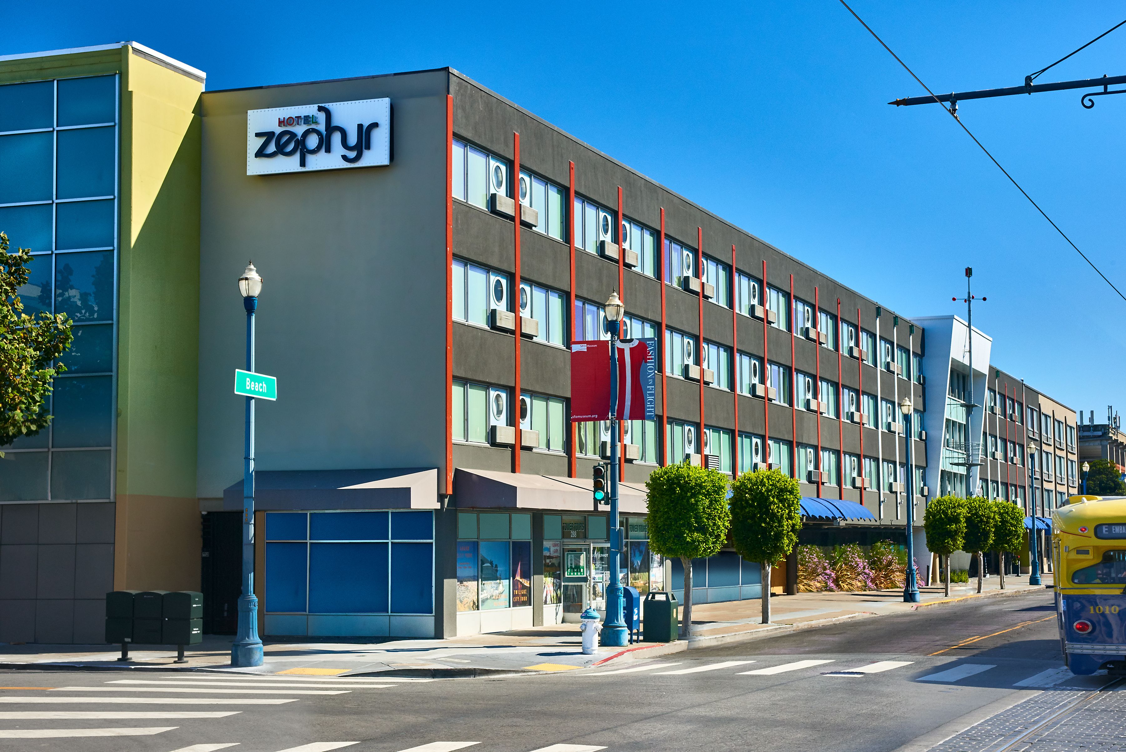 A hotel with a modern facade, multiple windows, and a prominent sign.