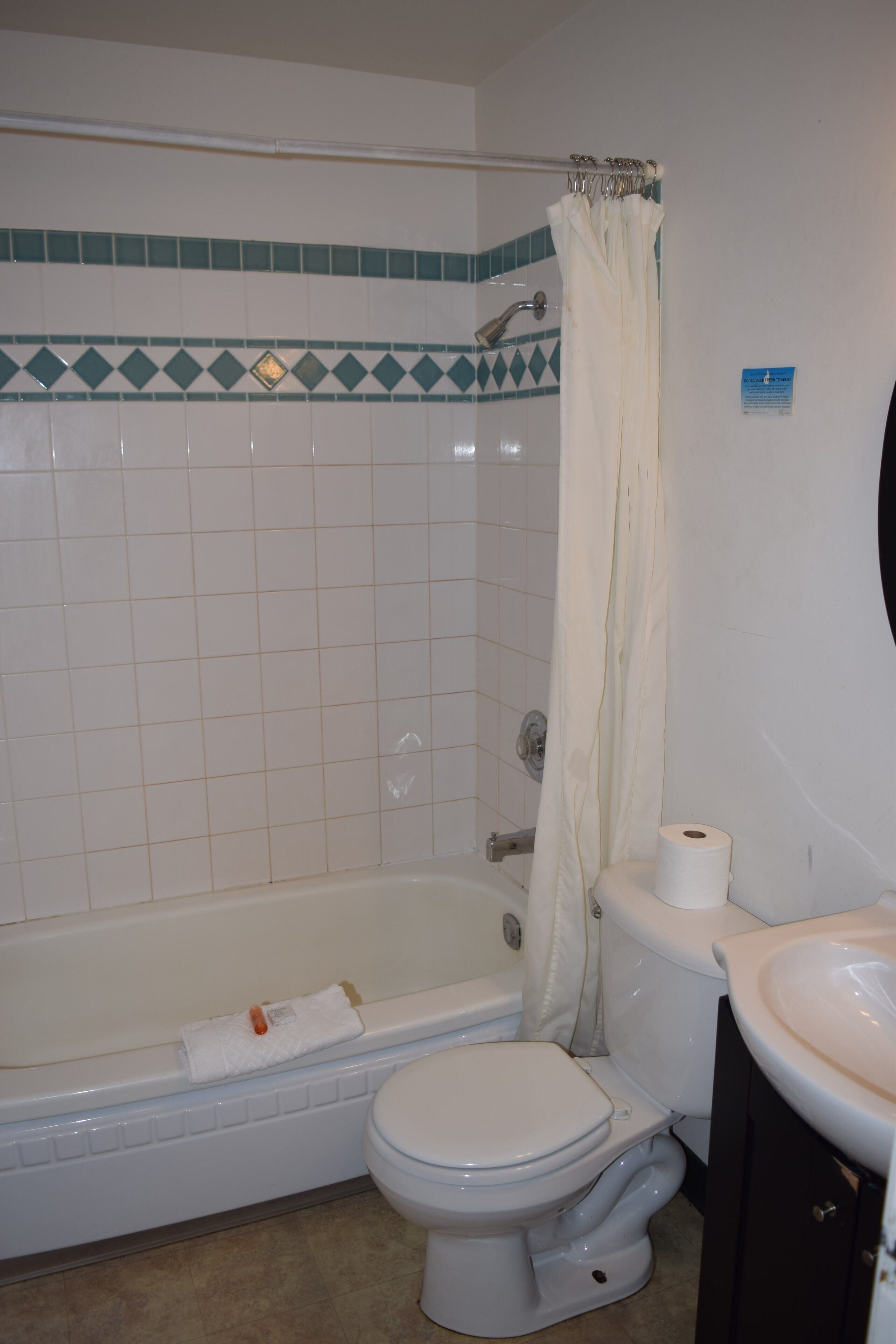 Un baño con bañera, inodoro y lavamanos.