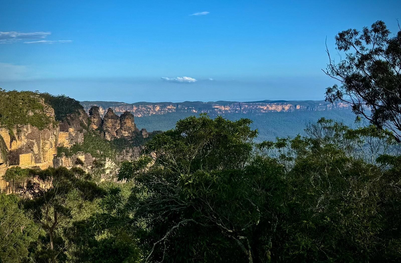 A mountainous landscape with rocky cliffs and dense greenery.