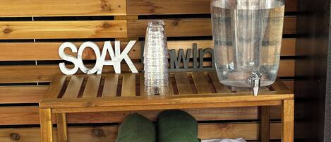 A wooden bench with a sign reading "SOAK" and a glass bottle.