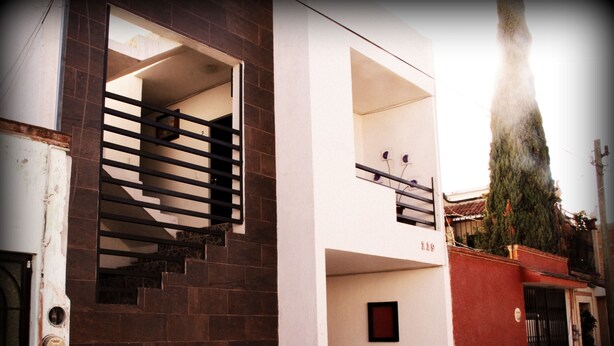 A two-story building with a staircase leading to an upper floor. - Residencia San Pablo (Querétaro)