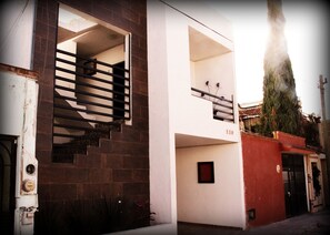 Un edificio de dos pisos con una escalera que lleva a un piso superior.