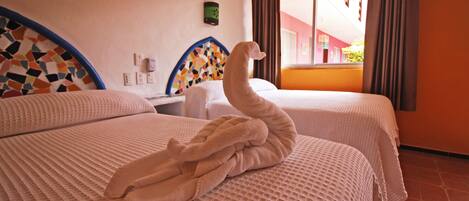 Habitación de hotel con dos camas, pared de azulejos, ventana con cortinas y un termostato en la pared.