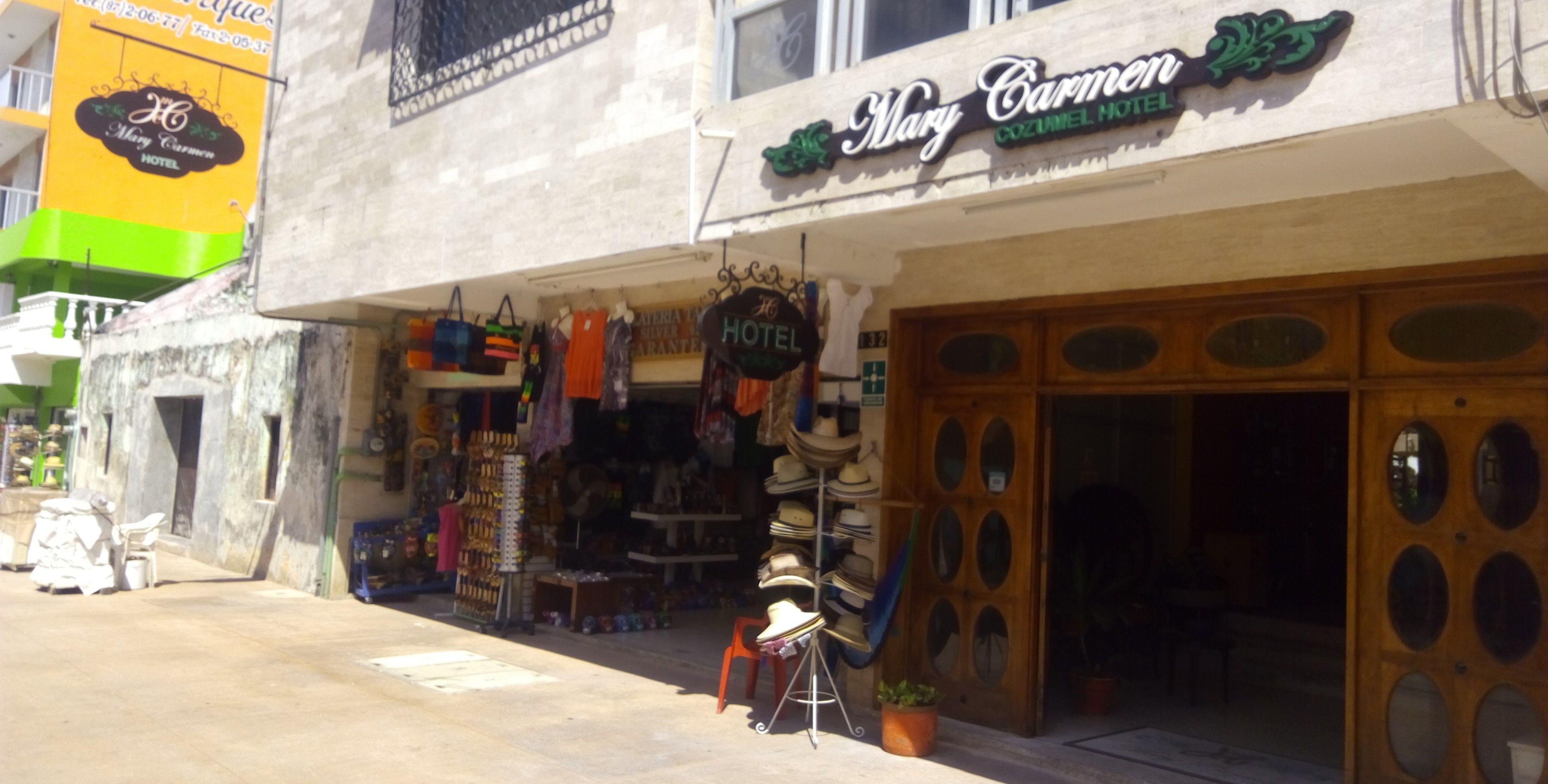 Entrada de un hotel con un letrero que dice 'Mary Carmen Hotel'.