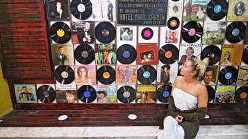 Una pared llena de discos de vinilo con portadas de álbumes, algunas con retratos de personas.