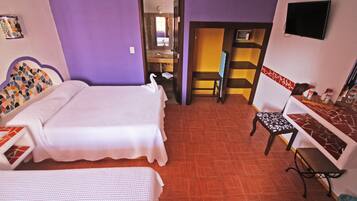 A hotel room with two beds, a desk, a chair, and a TV.