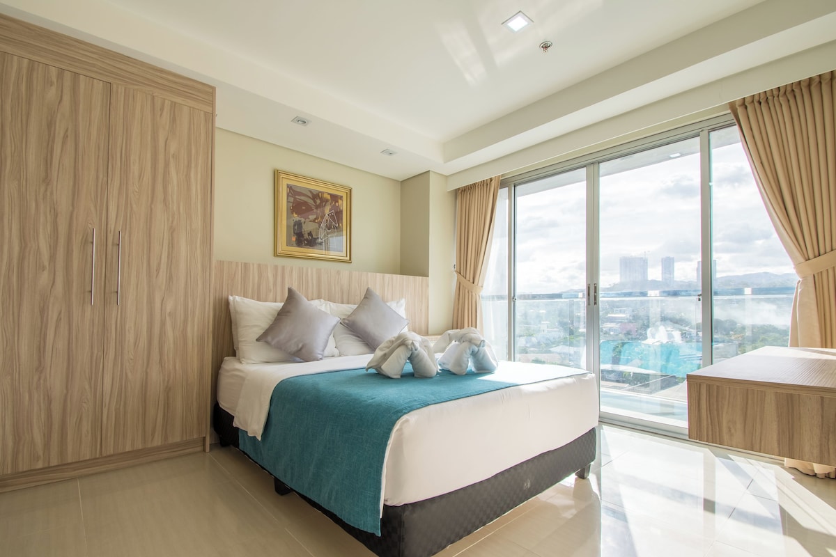 Una habitación de hotel moderna con una cama grande, vistas a la ciudad y un armario.
