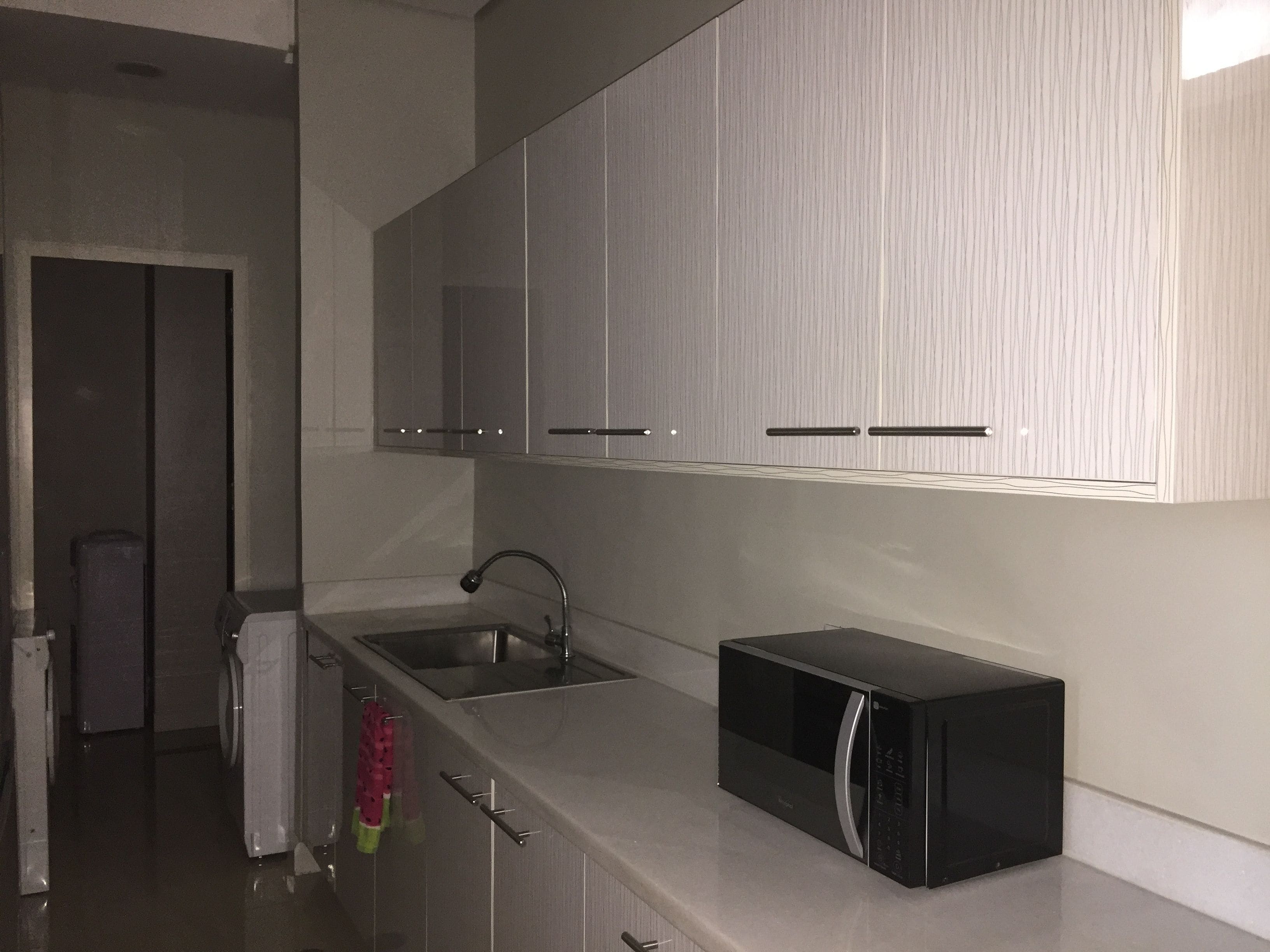 A modern kitchen with stainless steel appliances, a built-in microwave, and a sink.