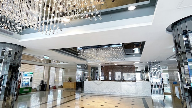 A spacious lobby with a marble reception desk, a high ceiling with hanging crystal chandeliers, and a clean, reflective floor. - Delton Hotel (Kaohsiung)