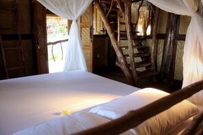 A bed with a canopy, wooden walls, and a staircase. - The Calmtree Bungalows (Canggu)