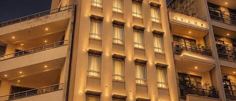 Un edificio de hotel moderno de gran altura con varios balcones y un cartel que dice 'NHAT HA MAISON'.