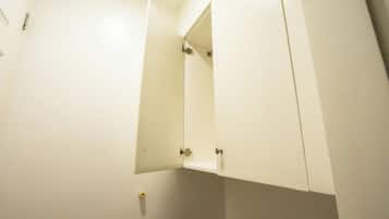 A bathroom with white walls, a mirror, and a door.