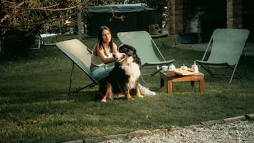 Un espacio al aire libre con césped, dos sillones y una pequeña mesa.