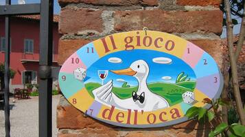 A colorful sign with a duck and the text "Il gioco dell'oca" on a brick wall.