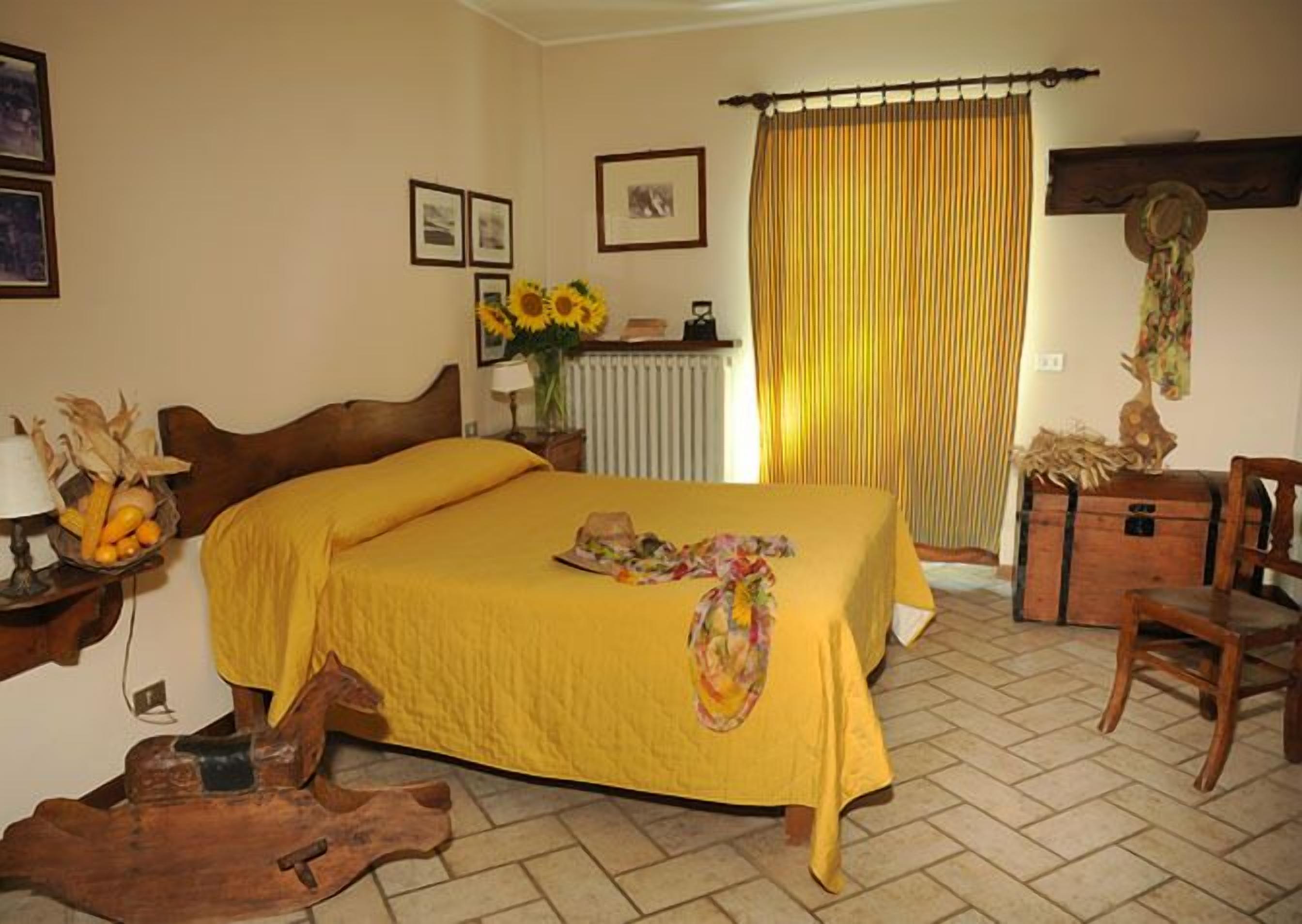 Une chambre à coucher avec un lit, une chaise en bois, une commode et un radiateur.