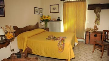 Une chambre à coucher avec un lit, une chaise en bois, une commode et un radiateur.