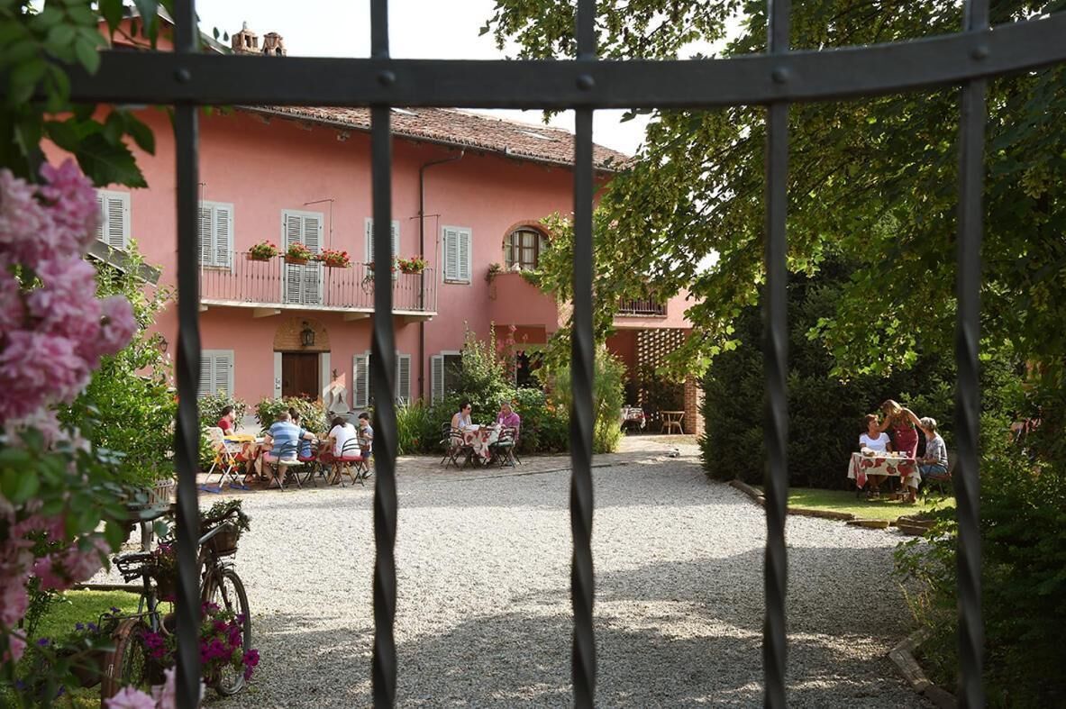 An outdoor patio area with tables and chairs, surrounded by a gravel path and greenery.