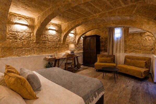 Una habitación acogedora con cama, escritorio, armario y sofá.